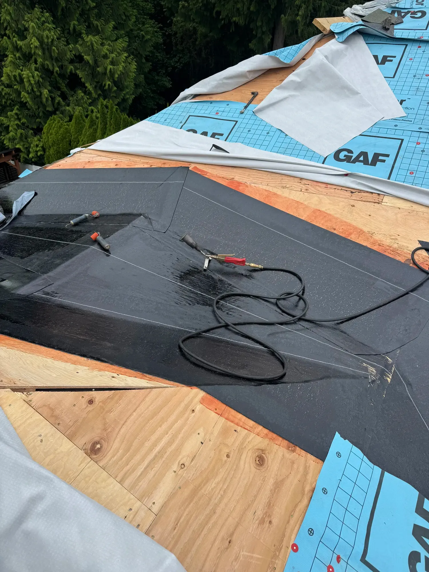 Roof deck, ice-and-water membrane, and synthetic underlayment going down before shingles on a Raindeer Roofing install