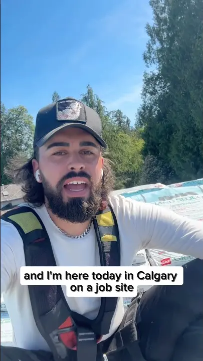 Blake, the owner of Raindeer Roofing, talking on a roof at a Calgary job site